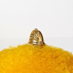 Gleaming gold accessory with a policemen's hat on a cheerful yellow background.