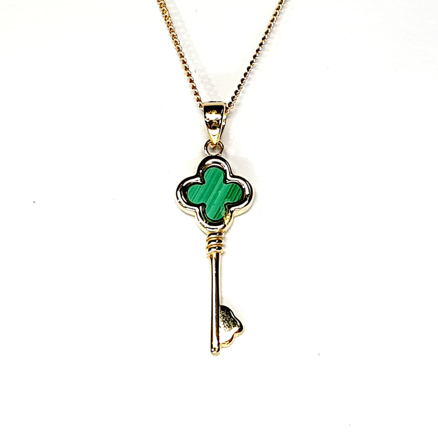 The same necklace shown from the front on a white backdrop, highlighting its fine gold detailing and natural malachite striping.