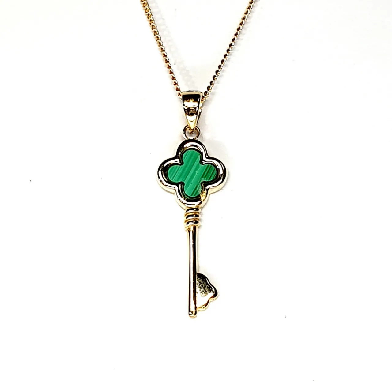 The same necklace shown from the front on a white backdrop, highlighting its fine gold detailing and natural malachite striping.