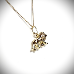 Close-up picture of a 3D lion necklace facing right, at a slight angle, focusing on the back tail end of the lion.