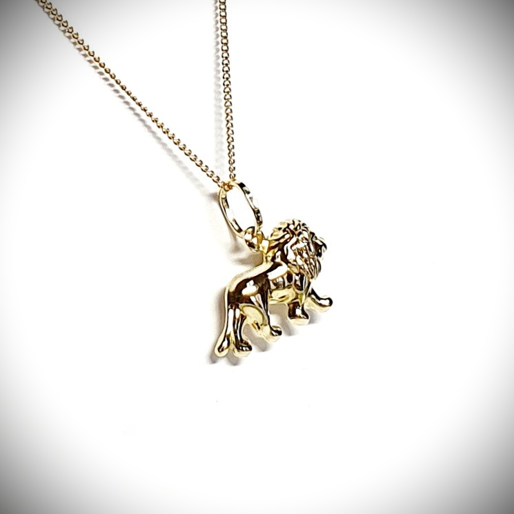 Close-up picture of a 3D lion necklace facing right, at a slight angle, focusing on the back tail end of the lion.