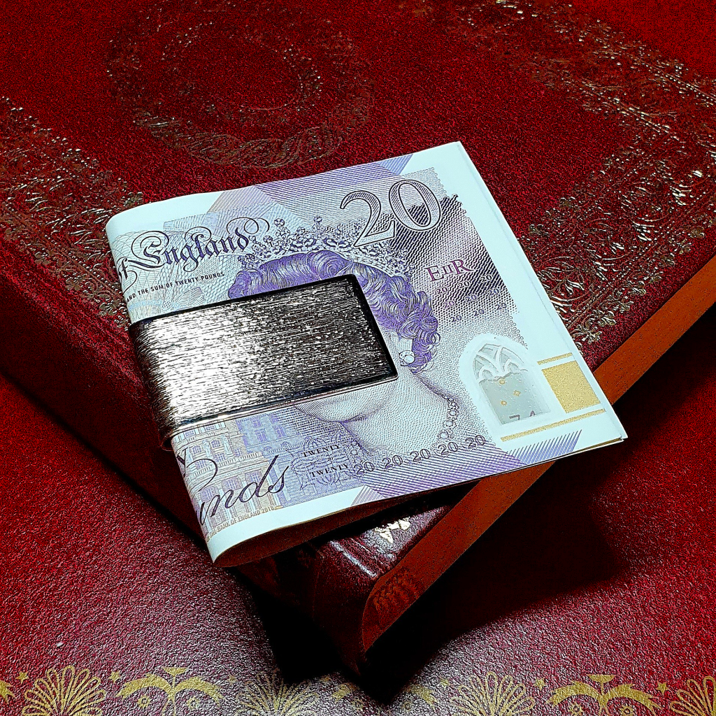 9-carat gold clip for your money with a barked pattern pictured with a £20.00 note.