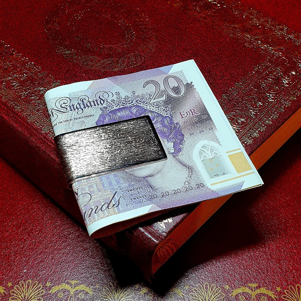 9-carat gold clip for your money with a barked pattern pictured with a £20.00 note.