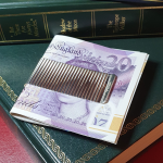Washboard design, sterling silver, two-sided cash clip pictured on green books with twenty pound notes.