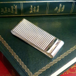 Washboard design, sterling silver, two-sided cash clip pictured on green books.