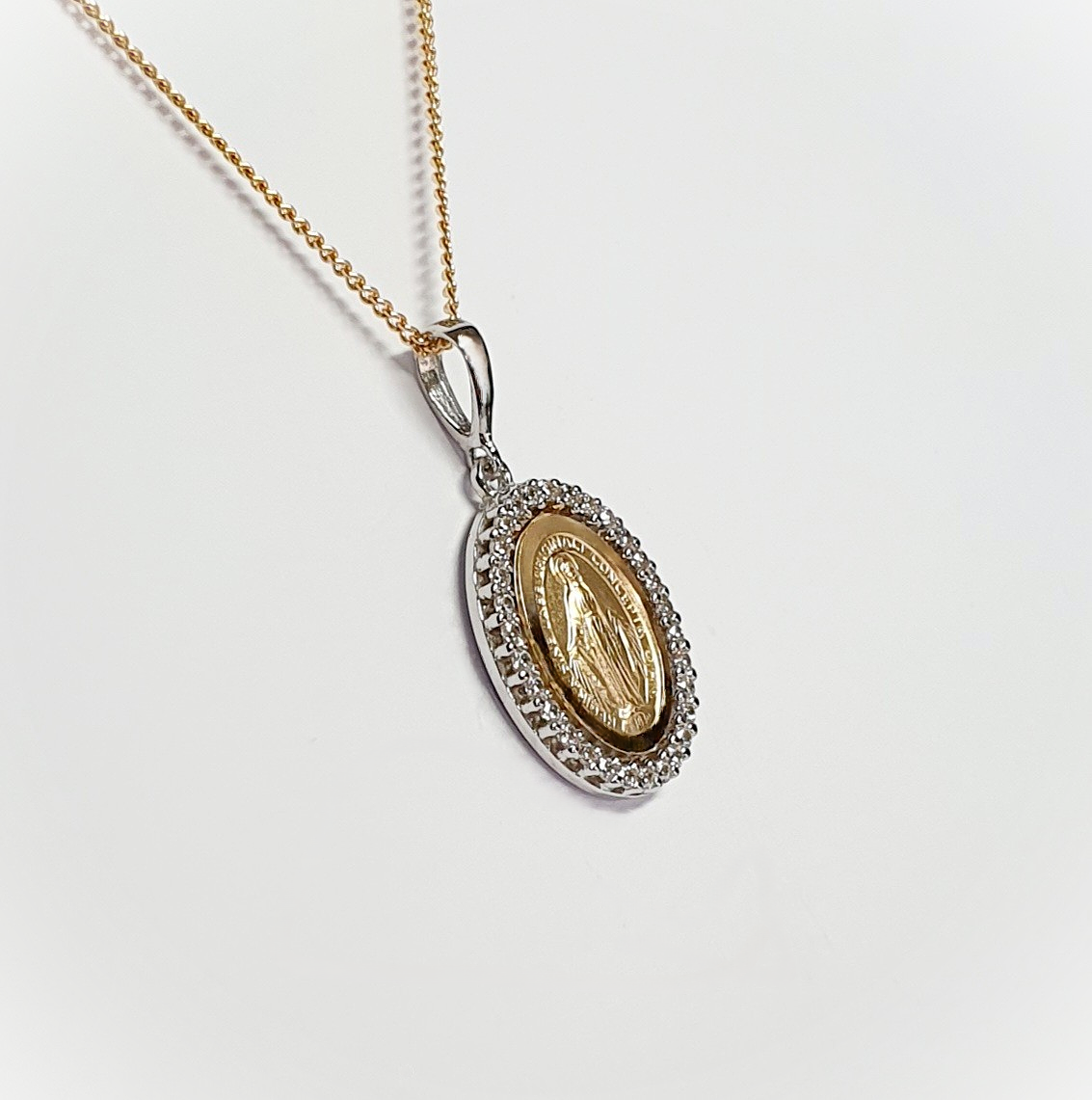 Two-tone 9-carat gold Madonna pendant and chain surrounded with cubic zirconia. The front view leans left to show at an angle.