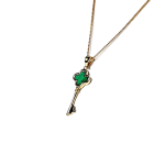 Side view of the 9ct gold malachite key necklace angled to the left, showing the depth of the pendant and the curvature of its key handle.