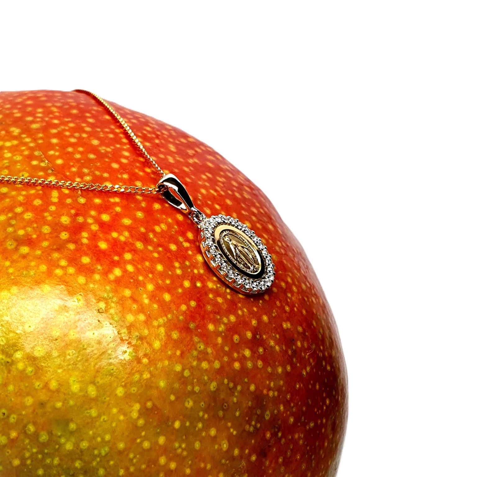 A two-tone 9-carat gold Madonna necklace is surrounded by a cubic zirconia border. The front view leans left to show at an angle pictured on a mango.