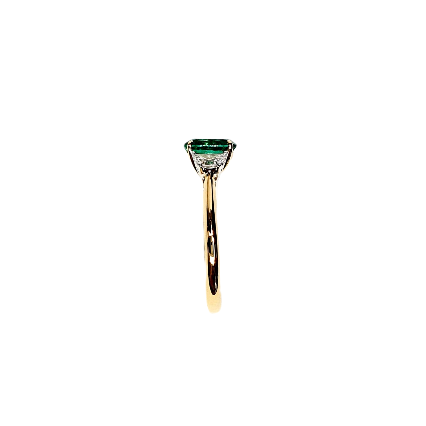 View of the shoulders showing the diamond attaching to the ring shank and the edge of the emerald.