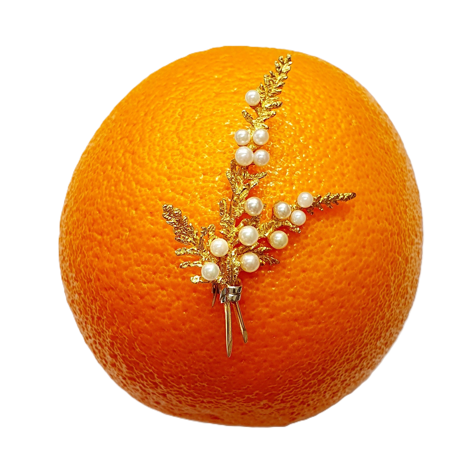 Yellow gold three sprig brooch pin with fourteen pearls pictured on an orange.