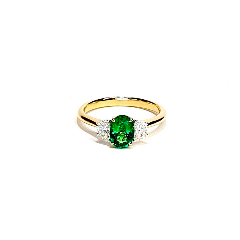 Photograph of the one oval emerald and two half-moon cut diamond ring lying on a flat surface RA00700.
