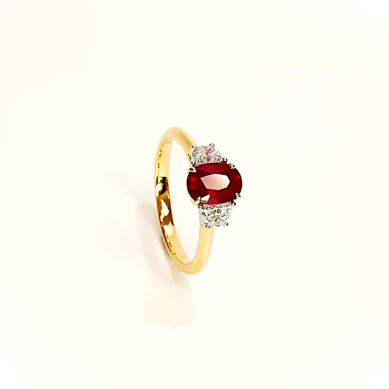 18ct yellow and white gold three stone ring with one oval ruby and two half moon diamonds, one on each side RA00698.