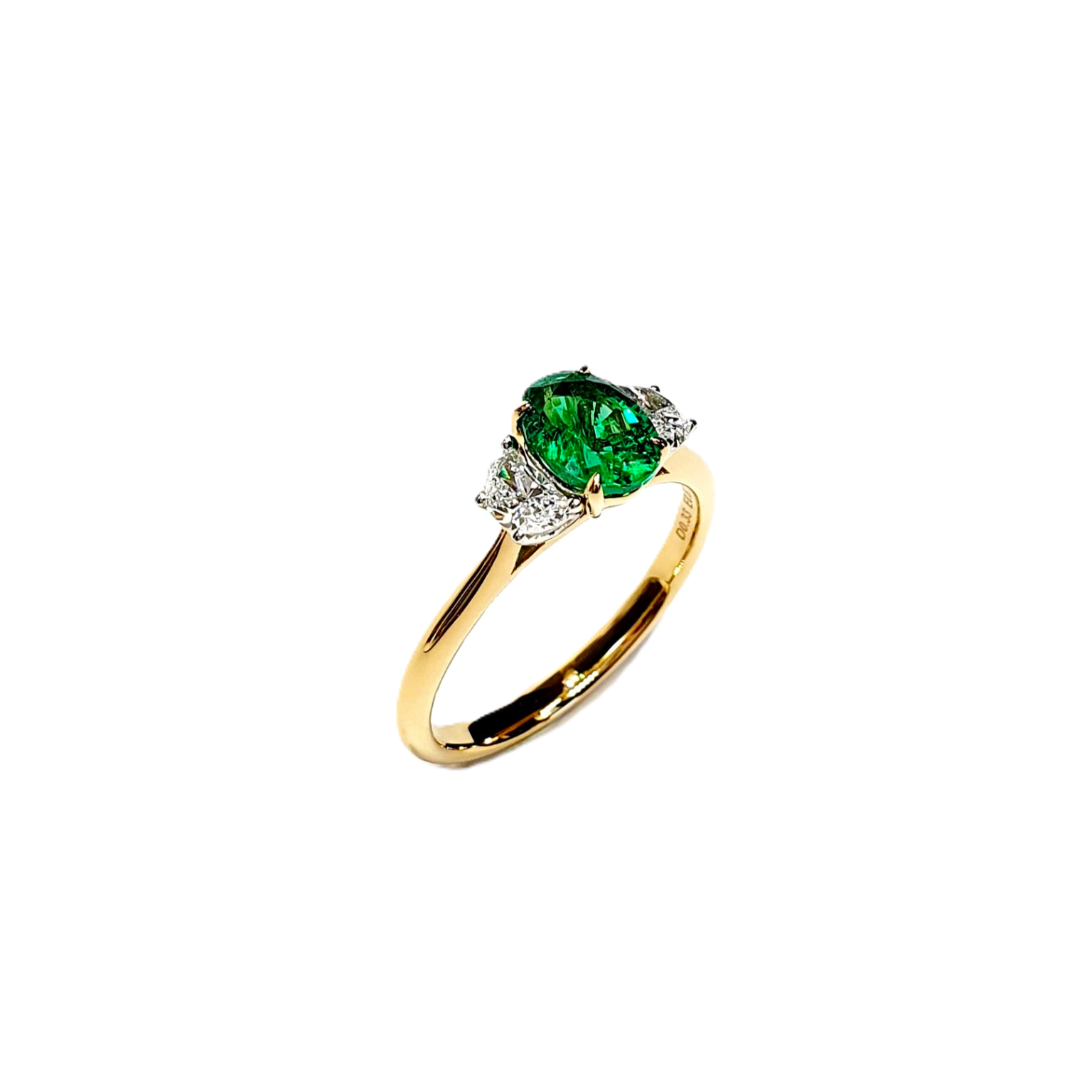Oval emerald & half moon diamonds three stone ring pictured at an angle facing right.
