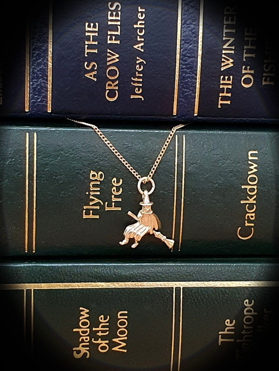 Picture of the witch landing on some giant books.