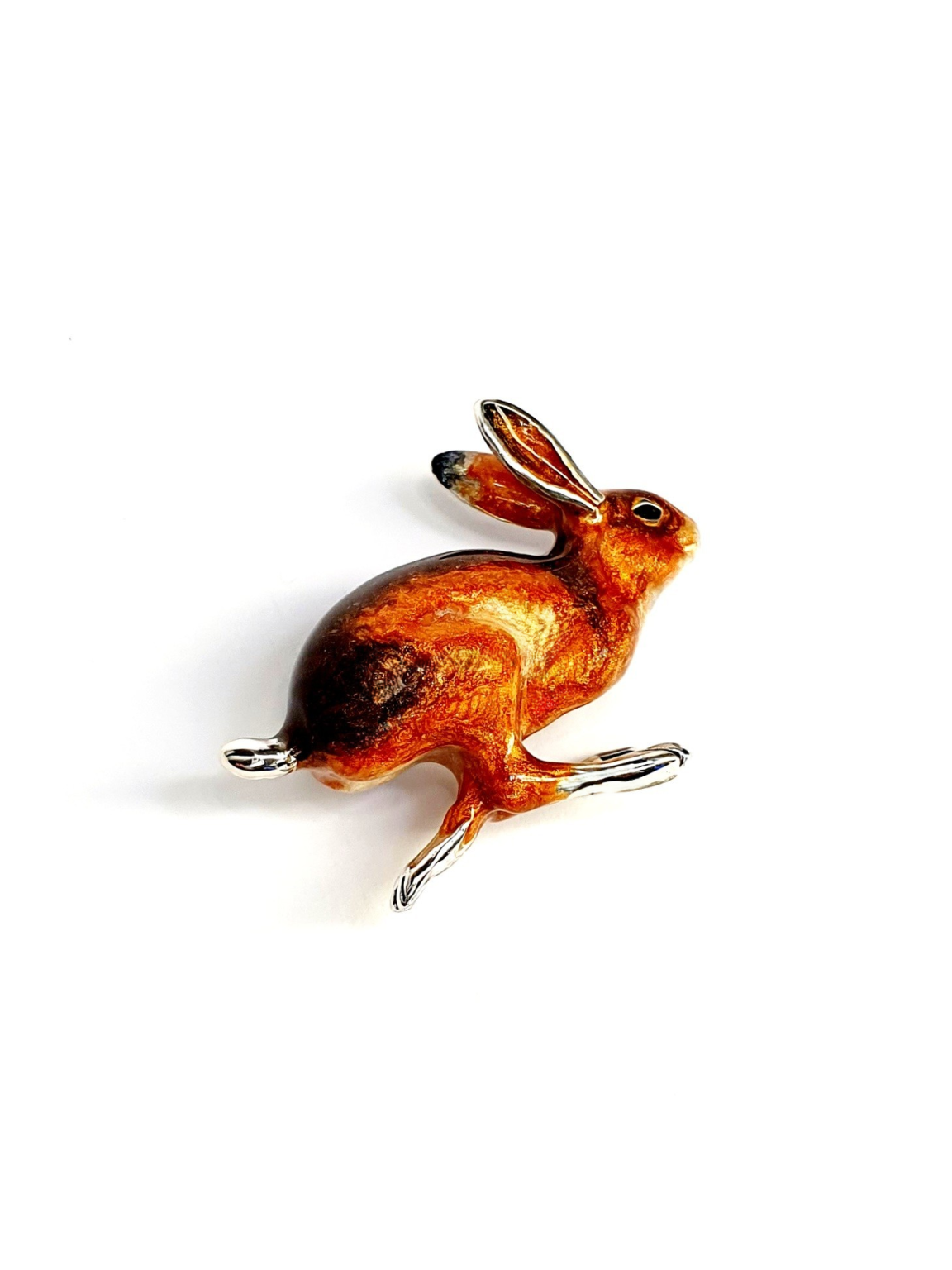 Sterling silver hare brooch with warm brown enamel tones pictured on a white background.