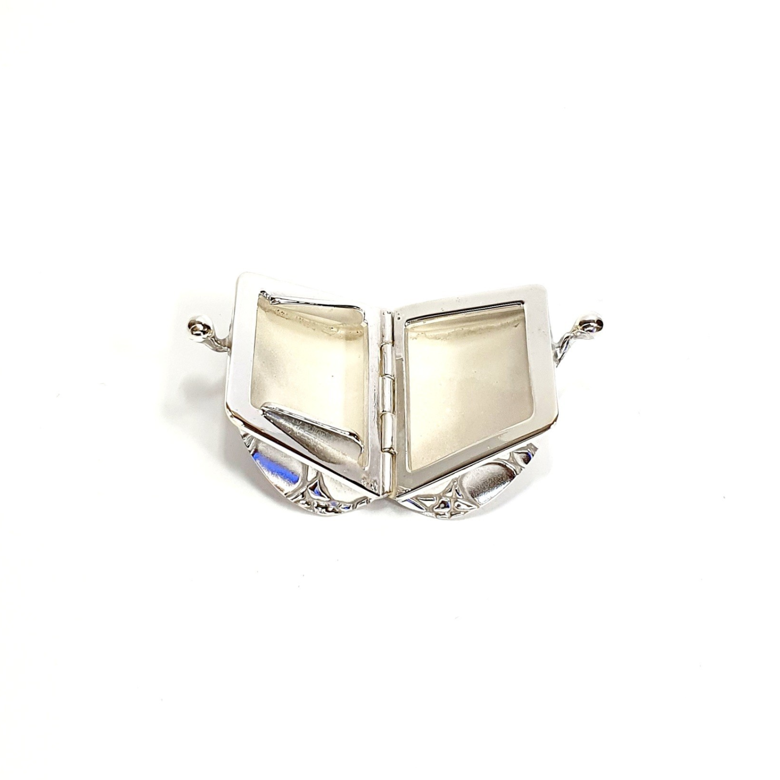 Sterling silver pill box opened wide, displaying full interior and lid curvature against neutral backdrop.