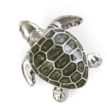Close-up of a sterling silver and green enamel turtle brooch, highlighting the detailed craftsmanship and polished finish.