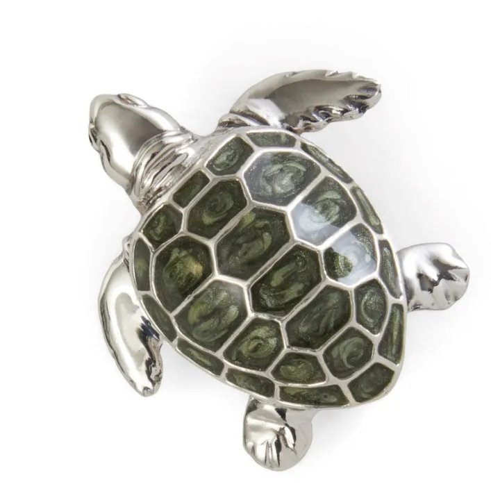 Close-up of a sterling silver and green enamel turtle brooch, highlighting the detailed craftsmanship and polished finish.