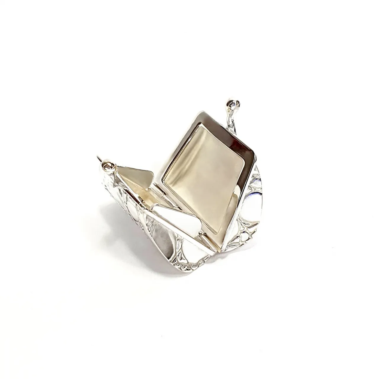 Sterling silver pill box opened, showing interior craftsmanship and hinge detail