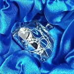 Silver pill box shaped like a classic ladies’ purse, resting in blue silk-lined gift box.