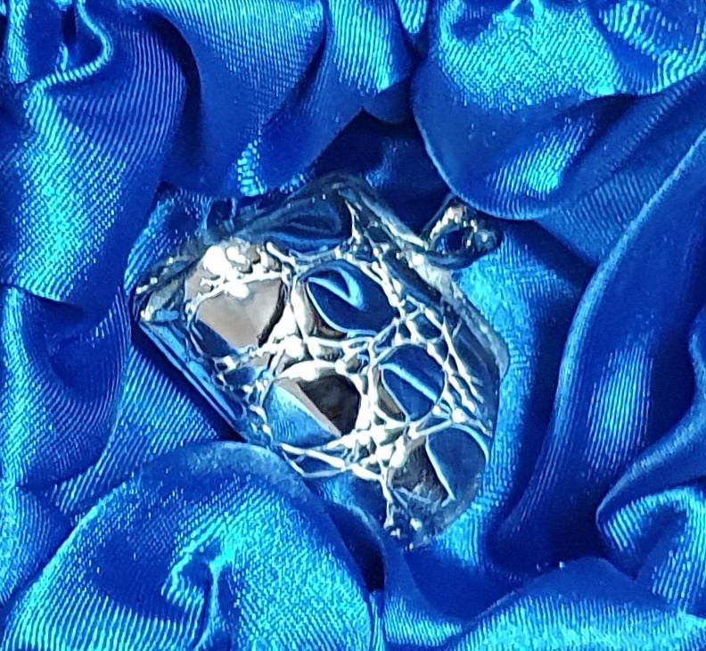 Silver pill box shaped like a classic ladies’ purse, resting in blue silk-lined gift box.