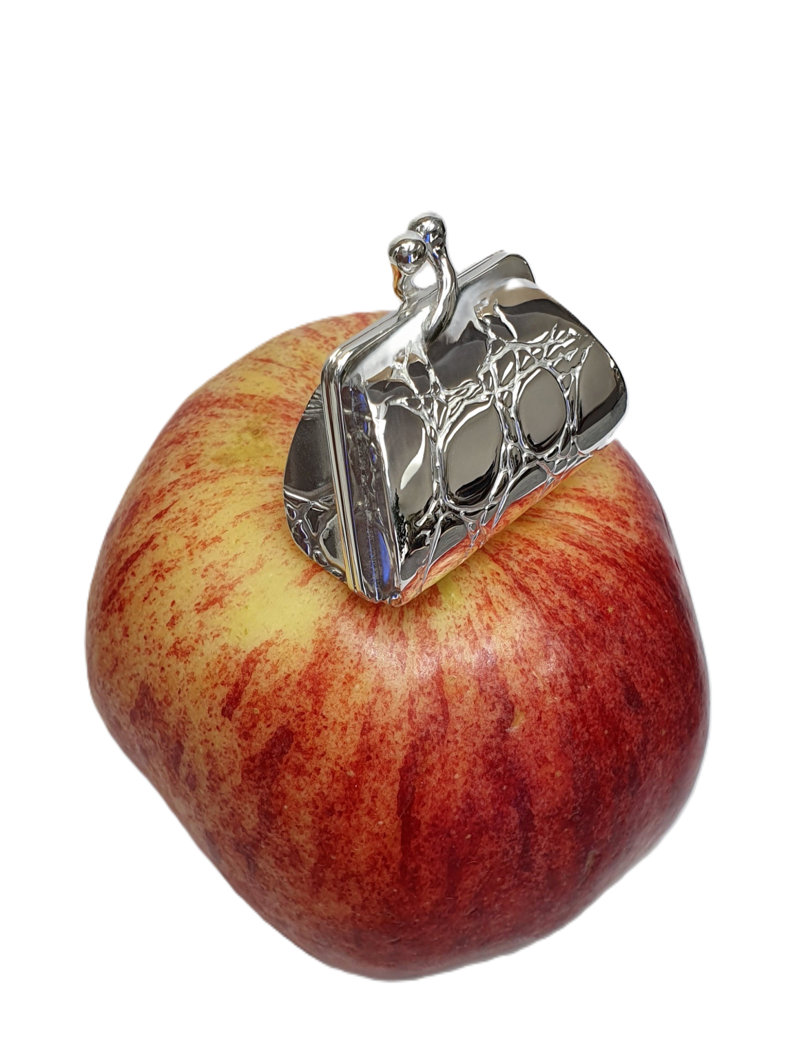Purse-inspired pill box displayed atop red apple to show compact scale and shine.