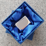 Sterling silver pill box in blue silk-lined gift box, displayed open to highlight elegant presentation packaging.