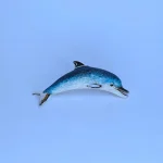 Lifelike enamelled Dolphin brooch made in Italy in genuine hallmarked silver. Pictured on a blue background.