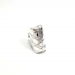 Sterling silver handbag pill box standing upright to display its hinged bottom, highlighting craftsmanship and secure closure detailing.