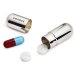 "Open sterling silver capsule pill box containing two white tablets and one red and blue sleeping capsule, displayed on a soft neutral background."