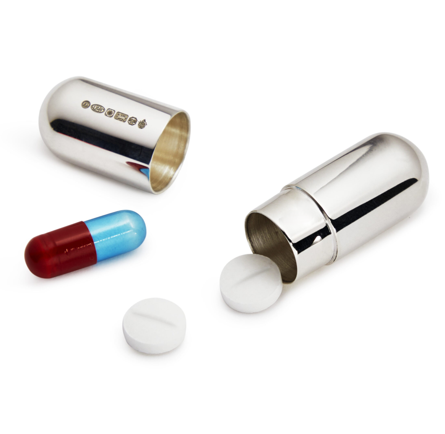 "Open sterling silver capsule pill box containing two white tablets and one red and blue sleeping capsule, displayed on a soft neutral background."