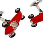 Side view of red enamel racing car cufflinks with black enamel tyres, inspired by vintage Grand Prix design.