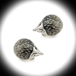 Sterling silver and enamel hedgehog cufflinks by Saturno displayed on a white background with a dark circular frame, emphasizing contrast and design detail.