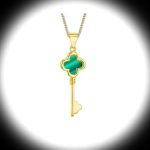 Front view with dramatic lighting The gold malachite key necklace stands centered beneath a focused spotlight on a white background, casting soft shadows and accentuating the gemstone’s natural banding.