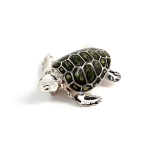 Angle view of the sterling silver enamelled turtle brooch against a neutral white background, highlighting its lustrous shell and intricate craftsmanship..
