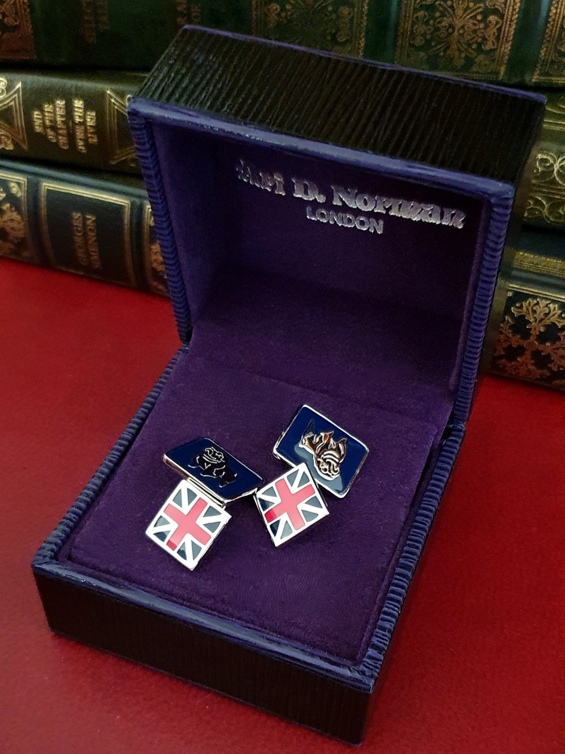 Sterling silver cufflink shown from a top angle, highlighting enamel detail and polished finish in a gift box.