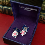 Sterling silver cufflink shown from a top angle, highlighting enamel detail and polished finish in a gift box.