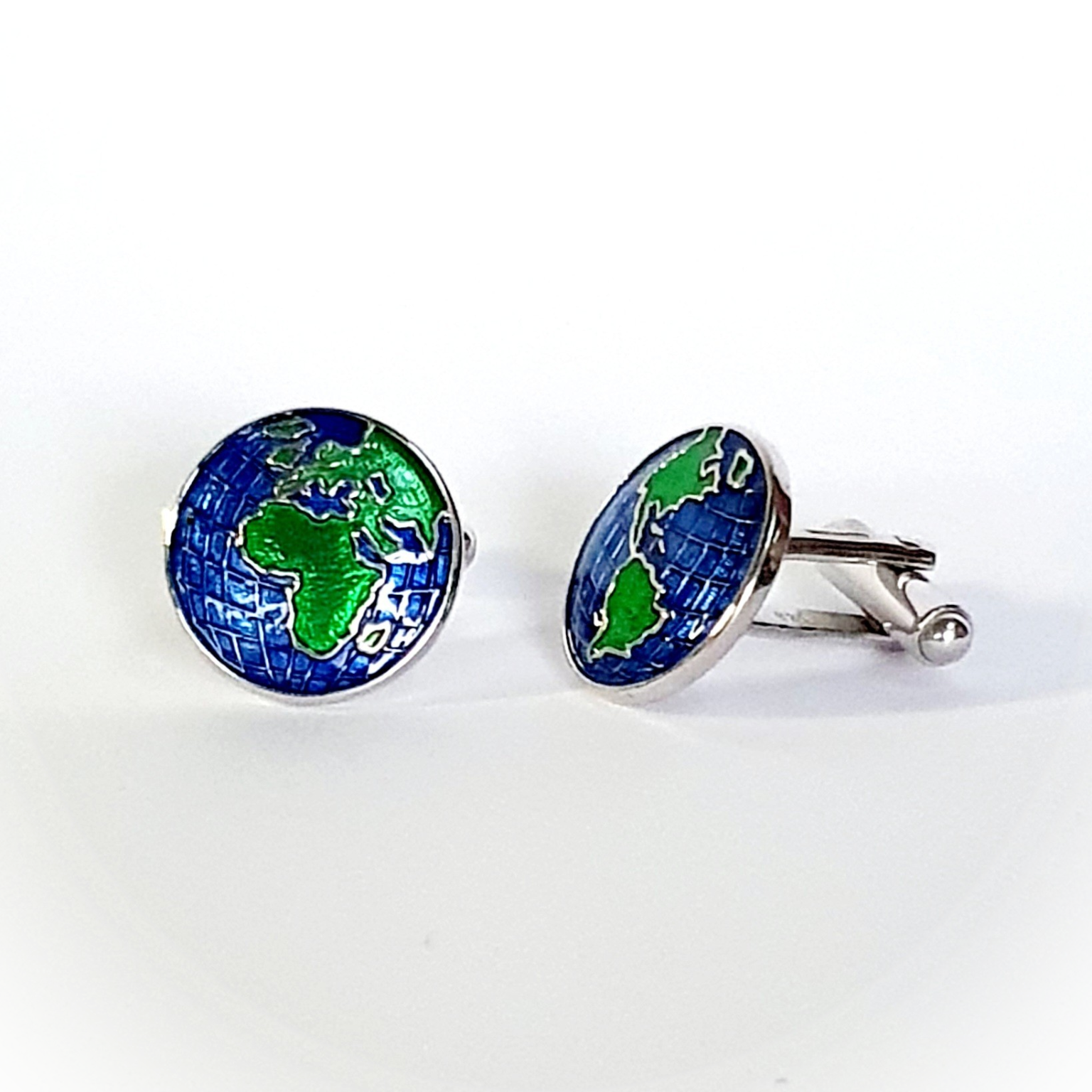 World map cufflinks shown with one facing front and one angled to the left, revealing enamel detail