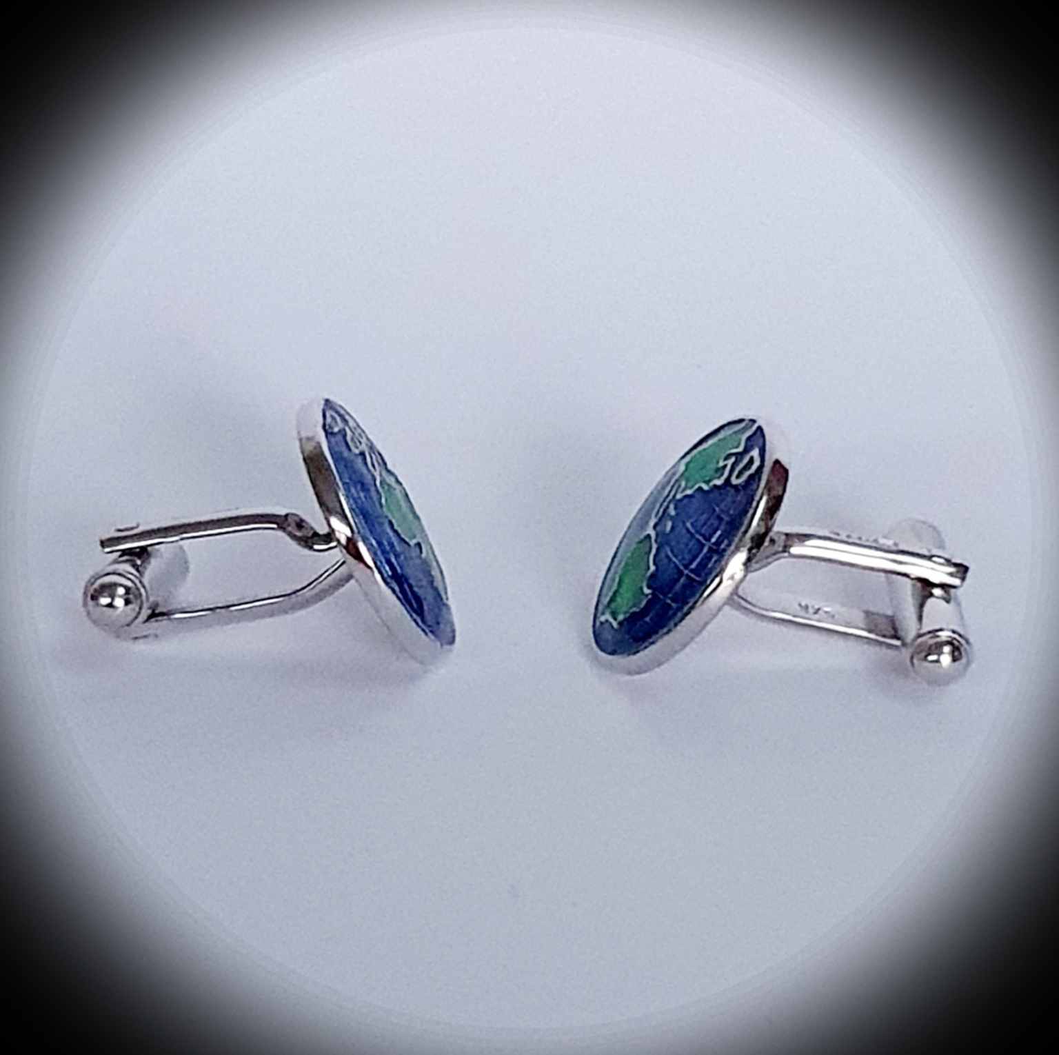 Spotlight effect on world map cufflinks, highlighting edge detailing and globe motif