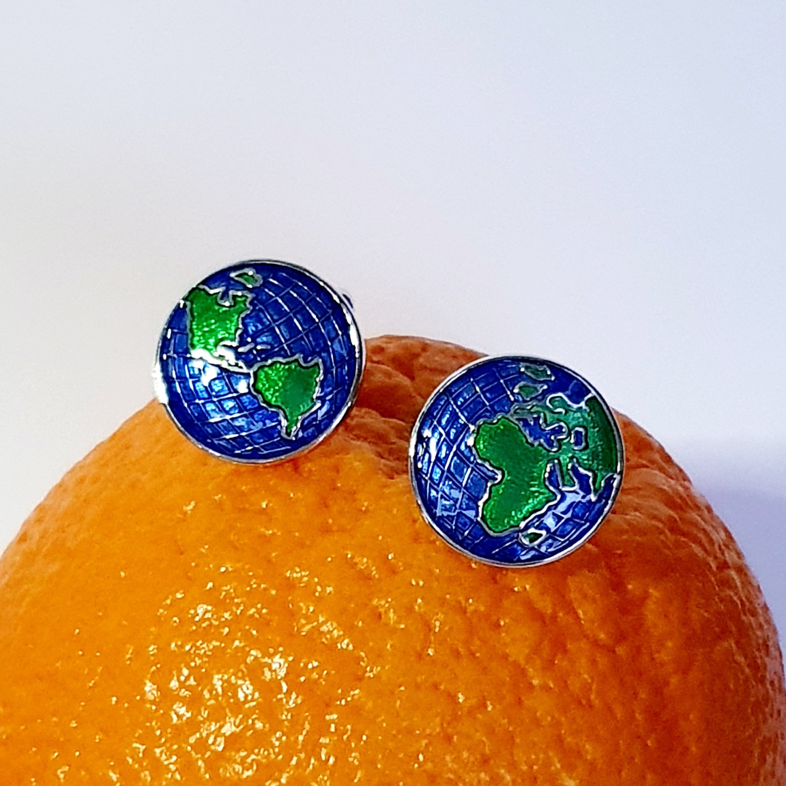 The Weldon cufflinks resting on an orange, highlighting colour contrast and playful styling