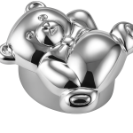 Close-up of silver teddy bear pillbox showing engraved face and bowtie on white background.