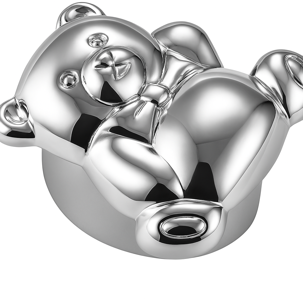 Close-up of silver teddy bear pillbox showing engraved face and bowtie on white background.
