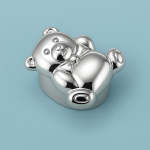 Silver teddy bear pillbox on turquoise background, polished surface, playful gift design.