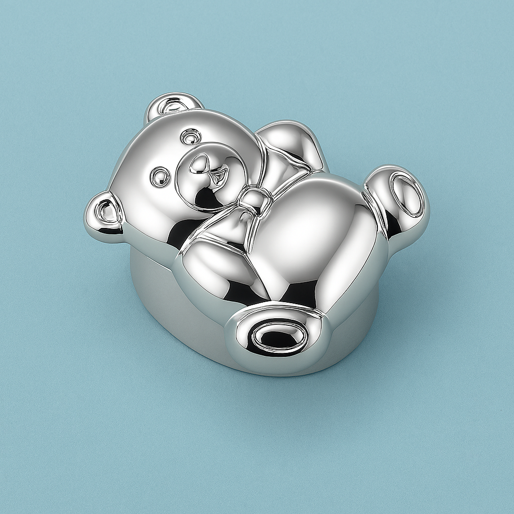 Silver teddy bear pillbox on turquoise background, polished surface, playful gift design.