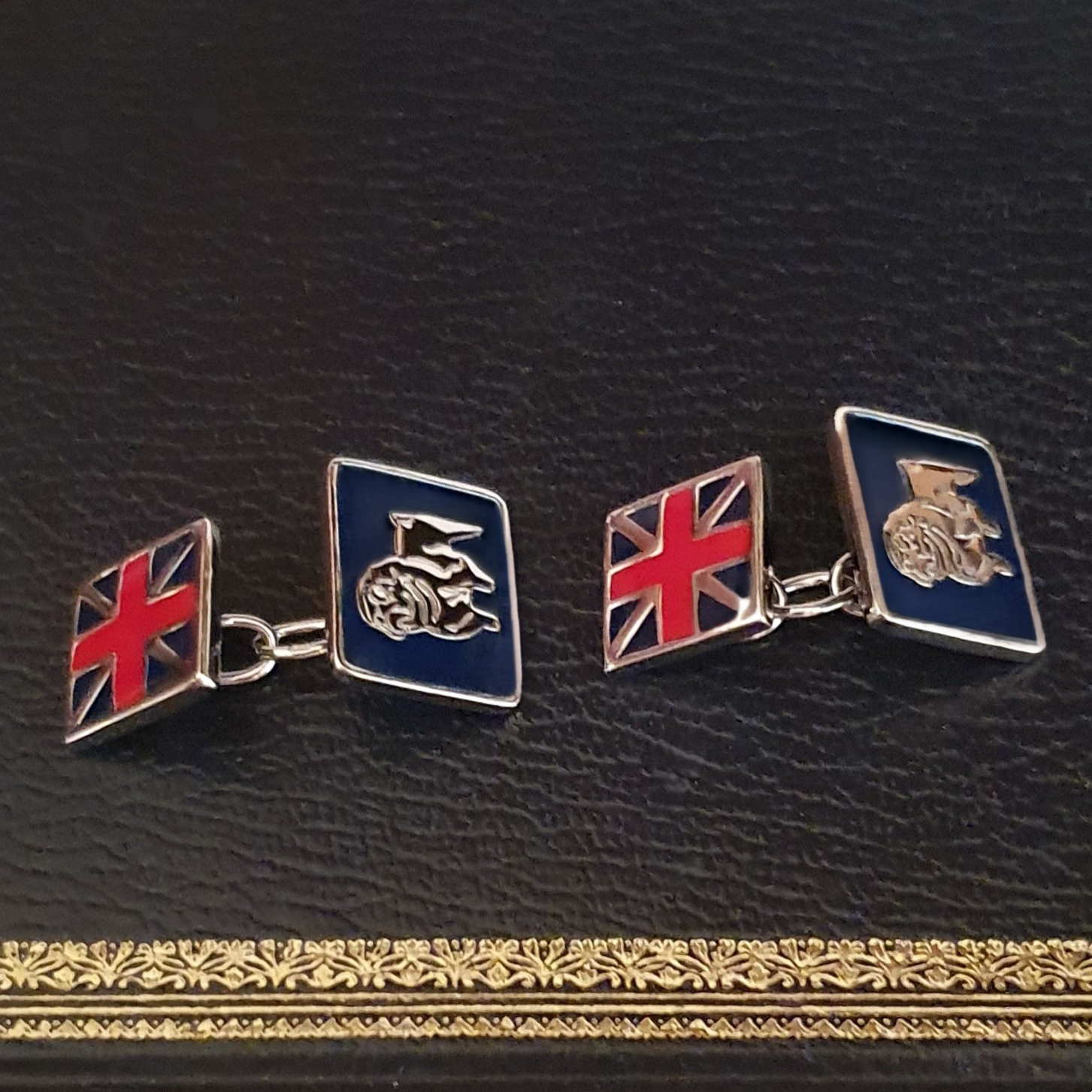 Sterling silver cufflink shown from a front angle, highlighting enamel detail and polished finish.