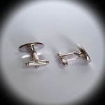 Reverse view of Treble Clef cufflinks under spotlight, showing secure toggle backs and polished finish