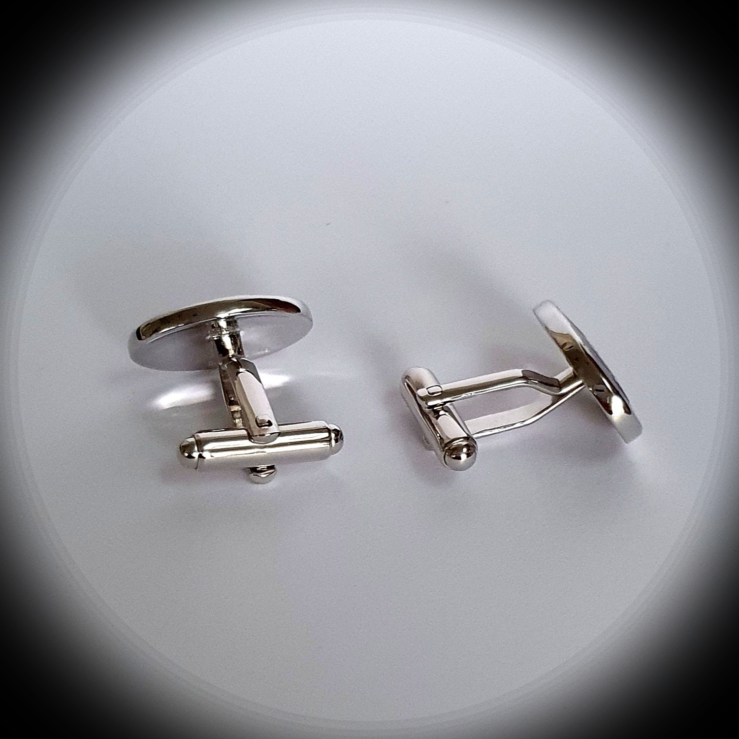Reverse view of Treble Clef cufflinks under spotlight, showing secure toggle backs and polished finish
