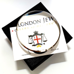 Dual-purpose luxury sterling silver desktop domed paperweight magnifying glass showing the ten times magnification on top of a business card