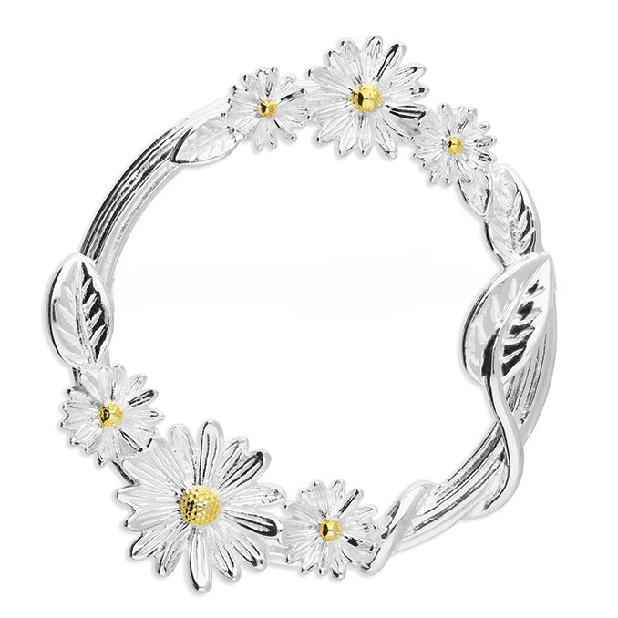 A clean white‑background photograph of the Sterling Silver Daisy Circle Brooch positioned as though it gently pierces a piece of plain white material. The two‑tone daisies, gold‑plated centre stamen and curved stem design stand out clearly against the simple backdrop.