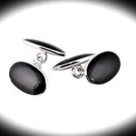 Black onyx oval cufflinks on a black background with a spotlight effect